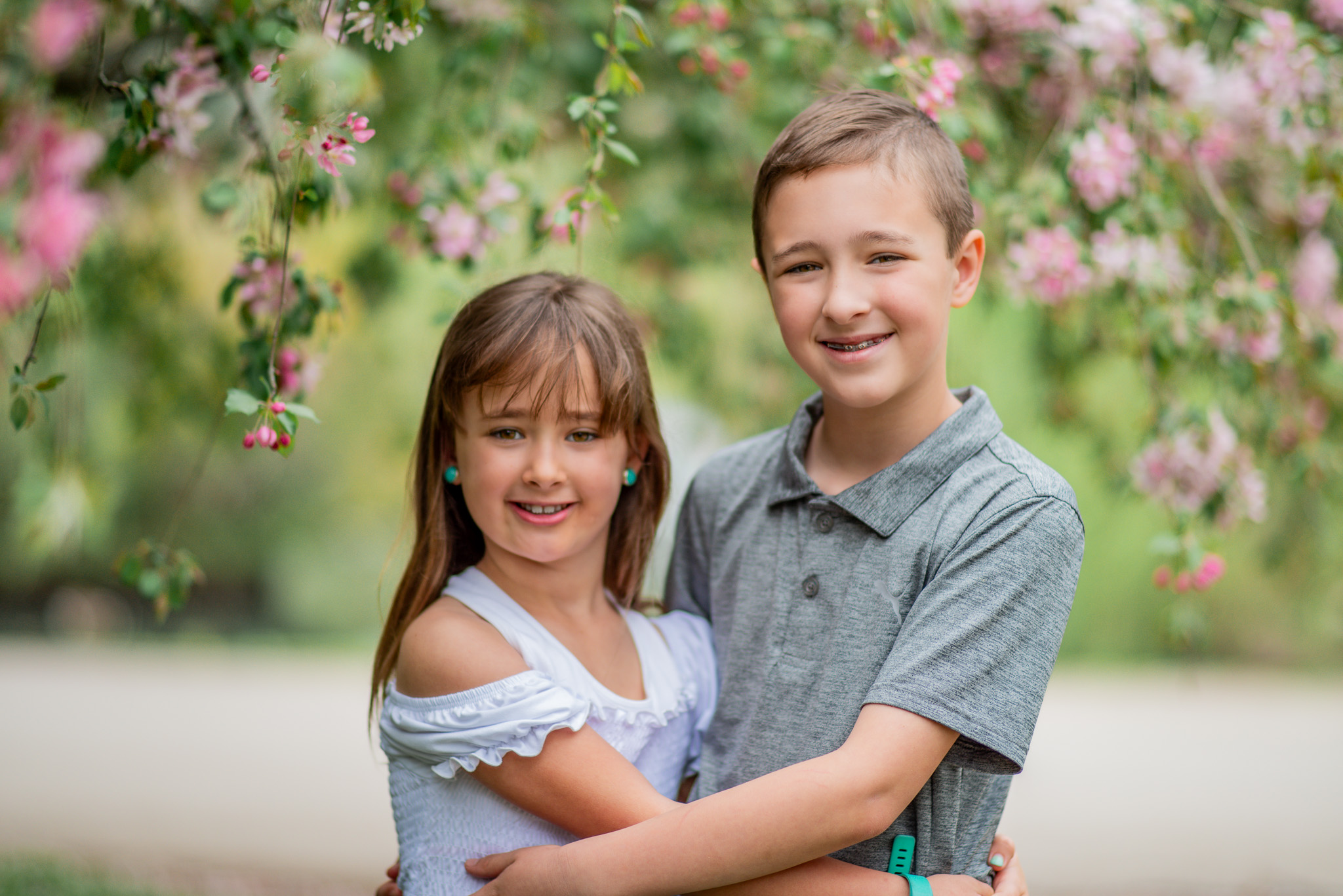 A family portrait of a brother and sister hugging.