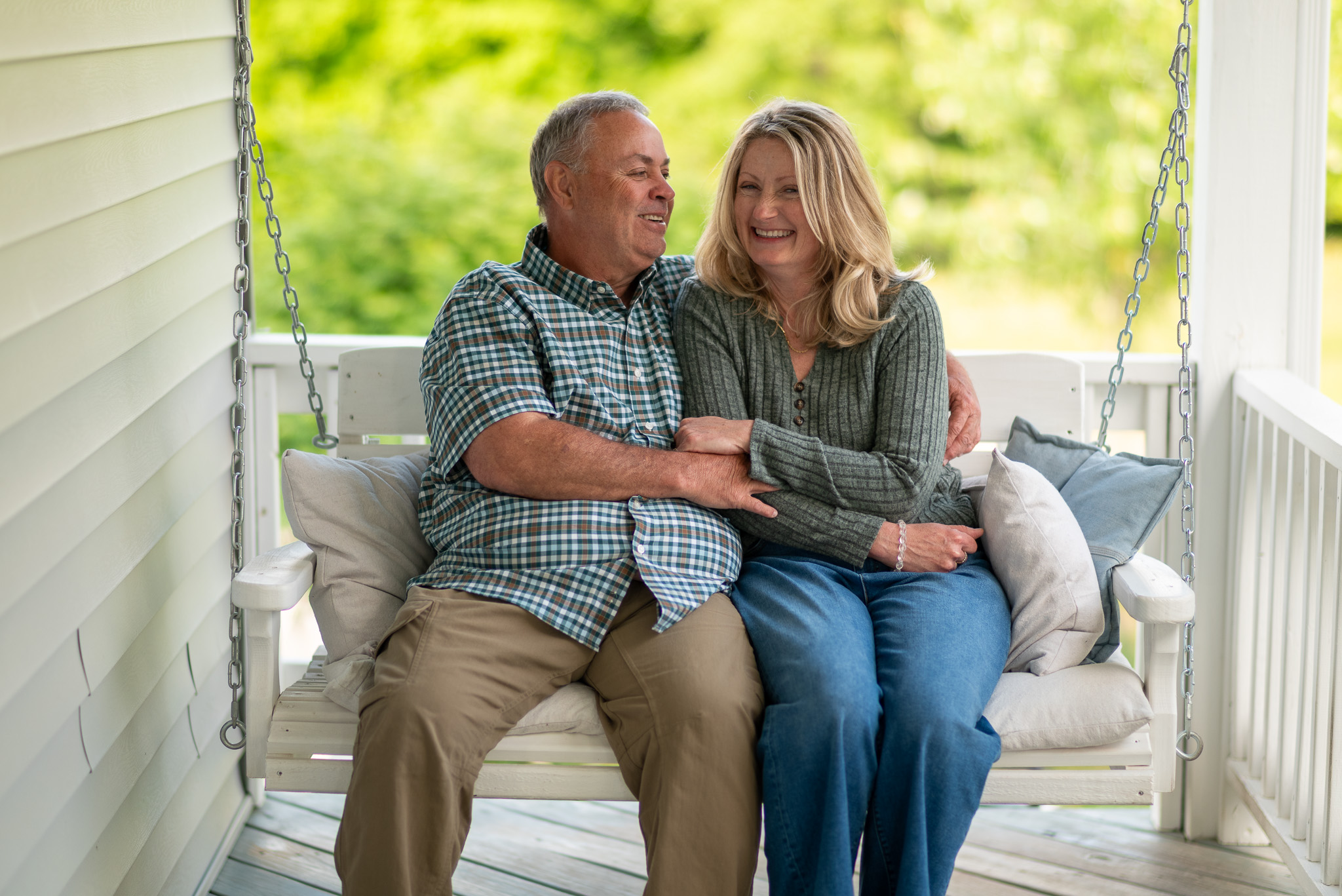 A portrait of a couple sitting together on a porch swing.