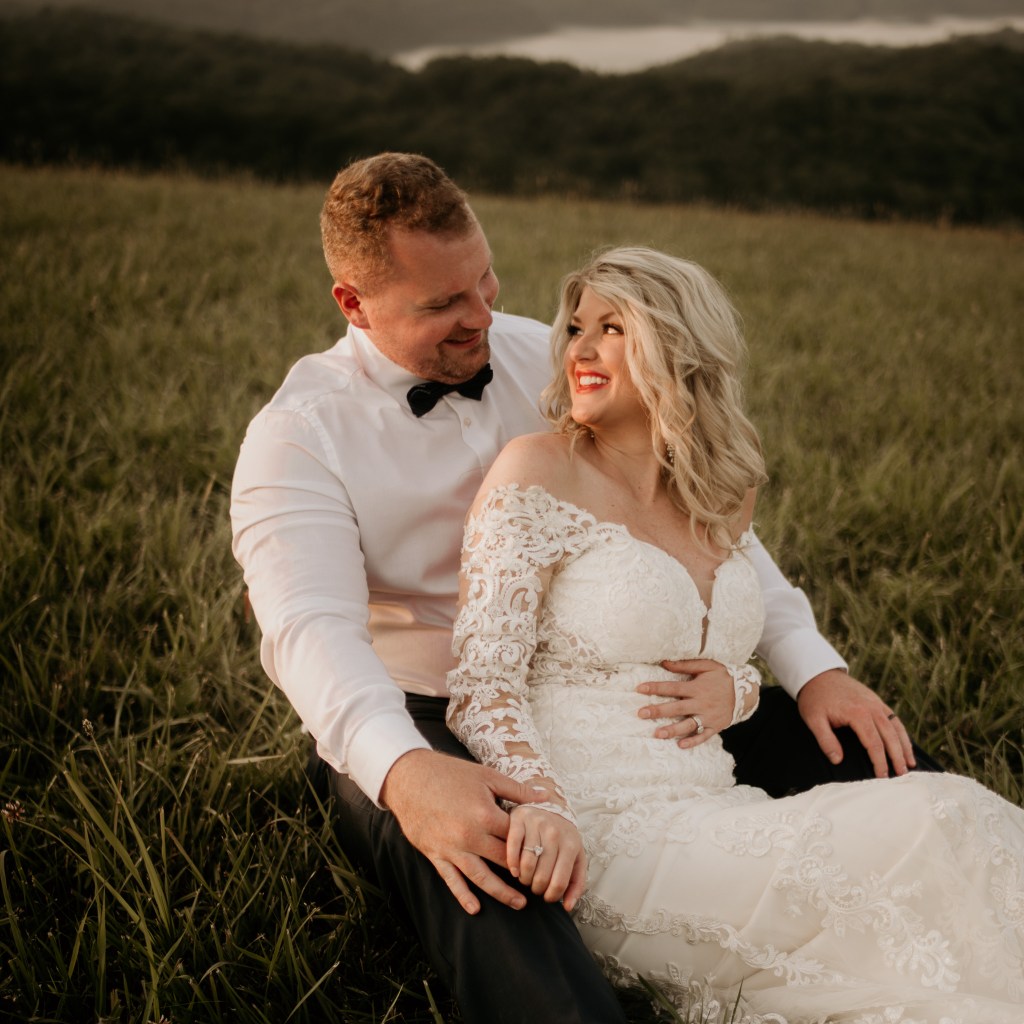 A wedding portrait of a bride and groom smiling at each other.